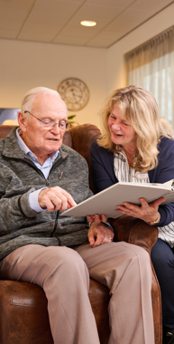 Een vrijwilliger leest met een bewoner.