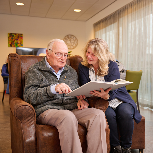 Een vrijwilliger leest met een bewoner.