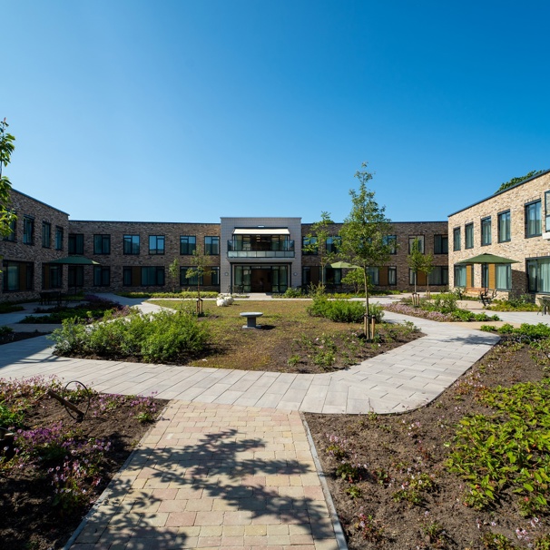 De tuin en het gebouw van woonzorgcentrum Anna Heide Ruim 80 ouderen met dementie wonen in woonzorgcentrum Heide. Een nieuw gebouw uit 2023 met een grote binnentuin en een mooi dakterras.