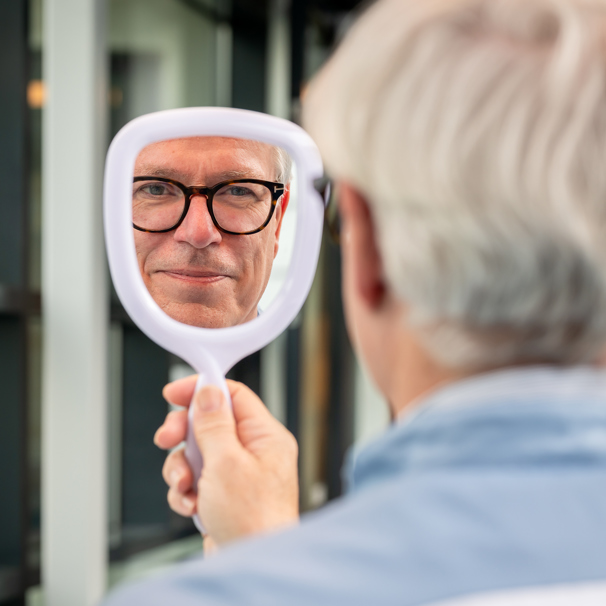 Apotheker Jan Pieter Schouten kijkt in spiegel
