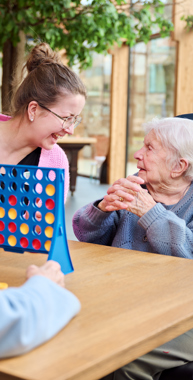 Een activiteitenbegeleidster speelt vier op een rij met twee bewoners Anna Ouderenzorg gaat samen met jou op zoek naar activiteiten die bij je passen.
